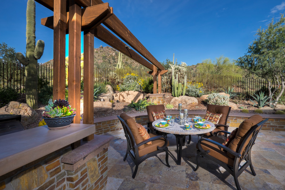 Design ideas for an expansive backyard patio in Phoenix with a fire feature, natural stone pavers and a pergola.