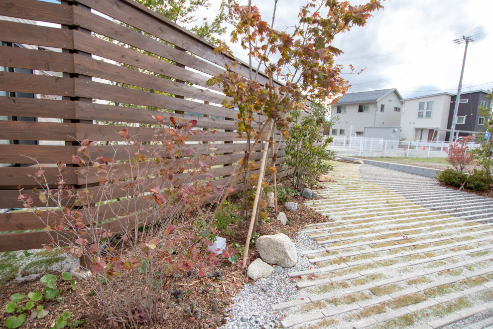 Cette image montre un jardin latéral nordique avec une exposition ensoleillée et une clôture en bois.