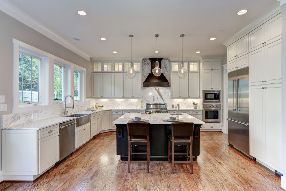 Inspiration for a large transitional u-shaped medium tone wood floor eat-in kitchen remodel in DC Metro with an undermount sink, raised-panel cabinets, white cabinets, marble countertops, white backsplash, metal backsplash, stainless steel appliances and an island