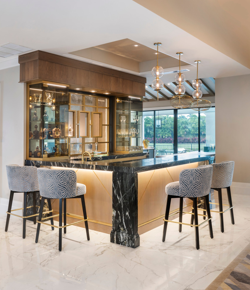 Expansive classic u-shaped wet bar in Miami with a built-in sink, glass-front cabinets, light wood cabinets, quartz worktops, porcelain flooring, white floors, black worktops and feature lighting.