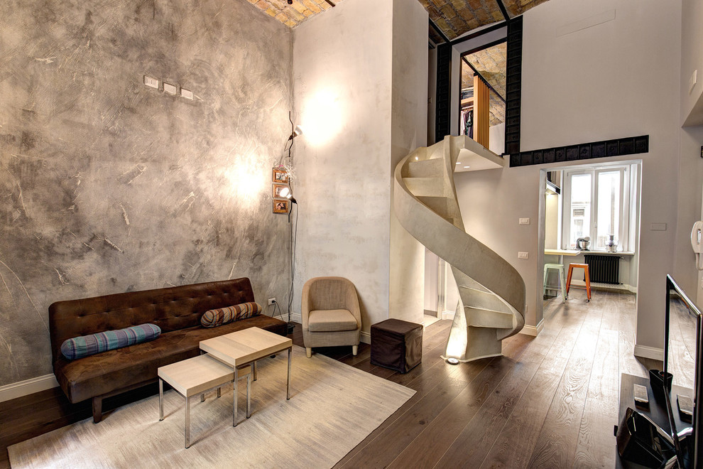 This is an example of an industrial living room in Rome with grey walls and dark hardwood floors.