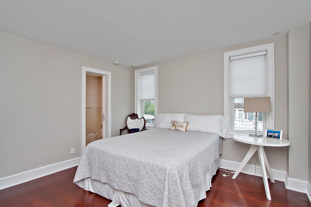 Mid-sized beach style guest bedroom in New York with grey walls and dark hardwood floors.