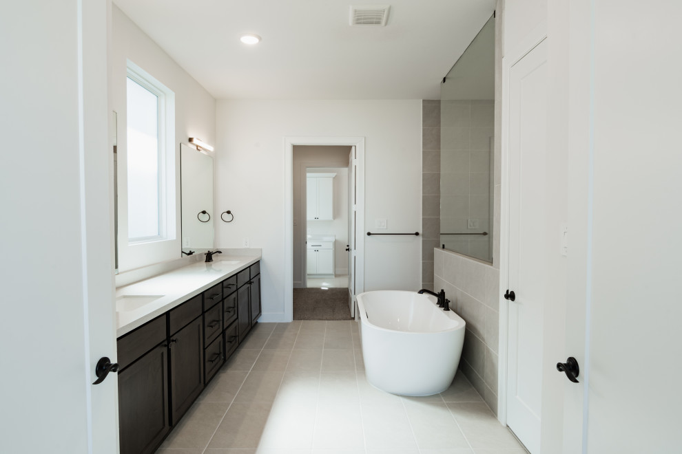 На фото: ванная комната среднего размера в современном стиле с отдельно стоящей ванной и тумбой под две раковины