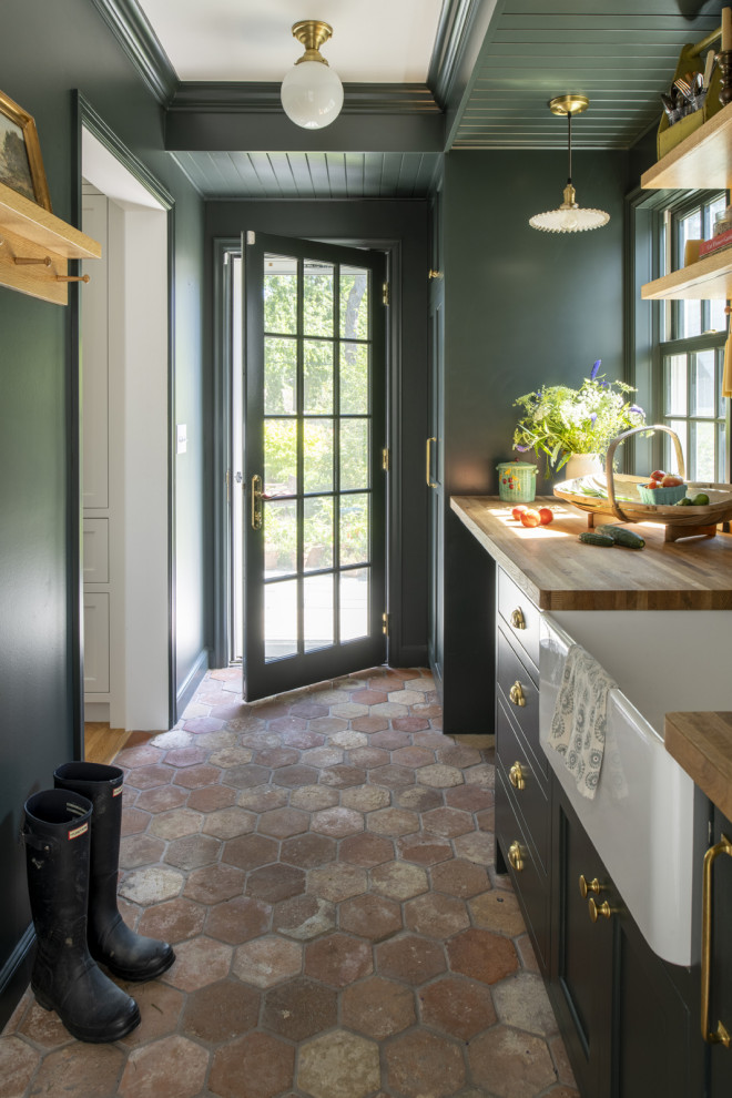 Design ideas for a medium sized classic galley kitchen pantry in Minneapolis with a belfast sink, green cabinets, wood worktops, terracotta flooring, brown floors and white worktops.