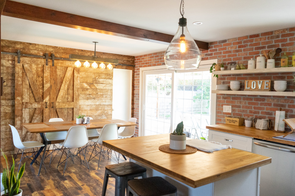 Inspiration for a country eat-in kitchen in Los Angeles with shaker cabinets, white cabinets, wood benchtops, red splashback, brick splashback, stainless steel appliances, with island, brown benchtop, dark hardwood floors and brown floor.