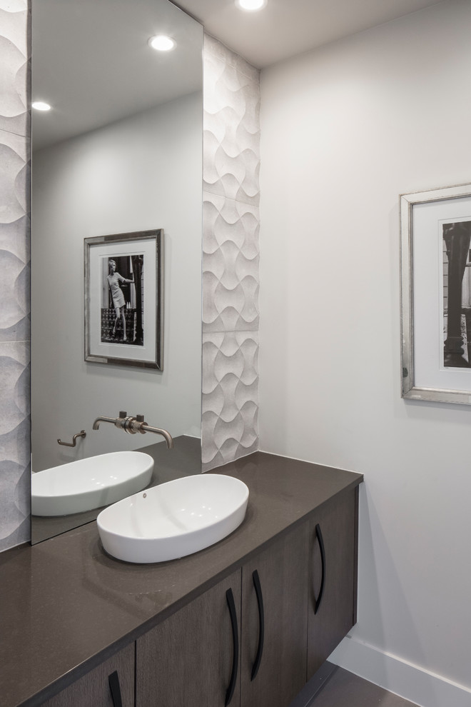 Inspiration for a mid-sized contemporary powder room in Austin with flat-panel cabinets, medium wood cabinets, white tile, limestone, white walls, porcelain floors, a vessel sink, engineered quartz benchtops, grey floor and grey benchtops.