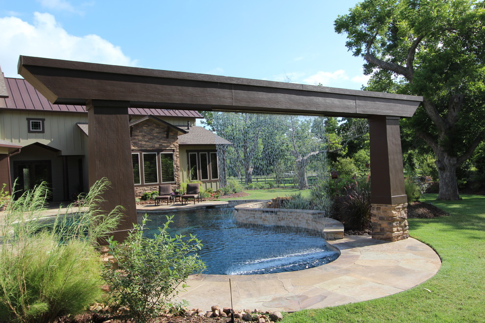 Large mountain style backyard tile and custom-shaped pool fountain photo in Houston