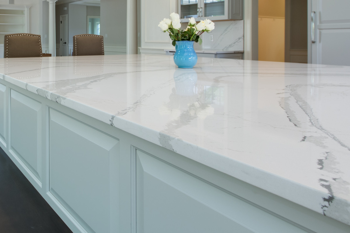 Example of a large transitional l-shaped medium tone wood floor open concept kitchen design in Boston with an undermount sink, raised-panel cabinets, gray cabinets, quartz countertops, stone slab backsplash, paneled appliances and an island
