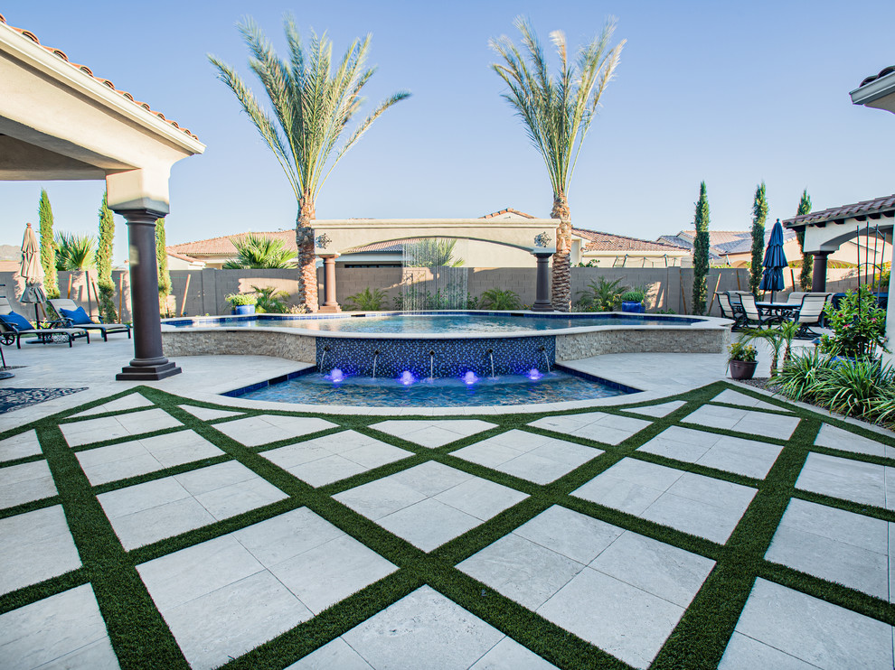 Mid-sized modern backyard custom-shaped pool in Phoenix with a water feature and concrete pavers.