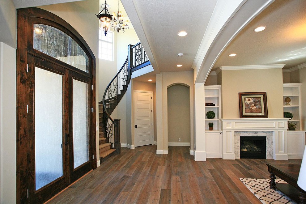 This is an example of a large traditional foyer in Salt Lake City with grey walls, dark hardwood floors, a double front door and a dark wood front door.