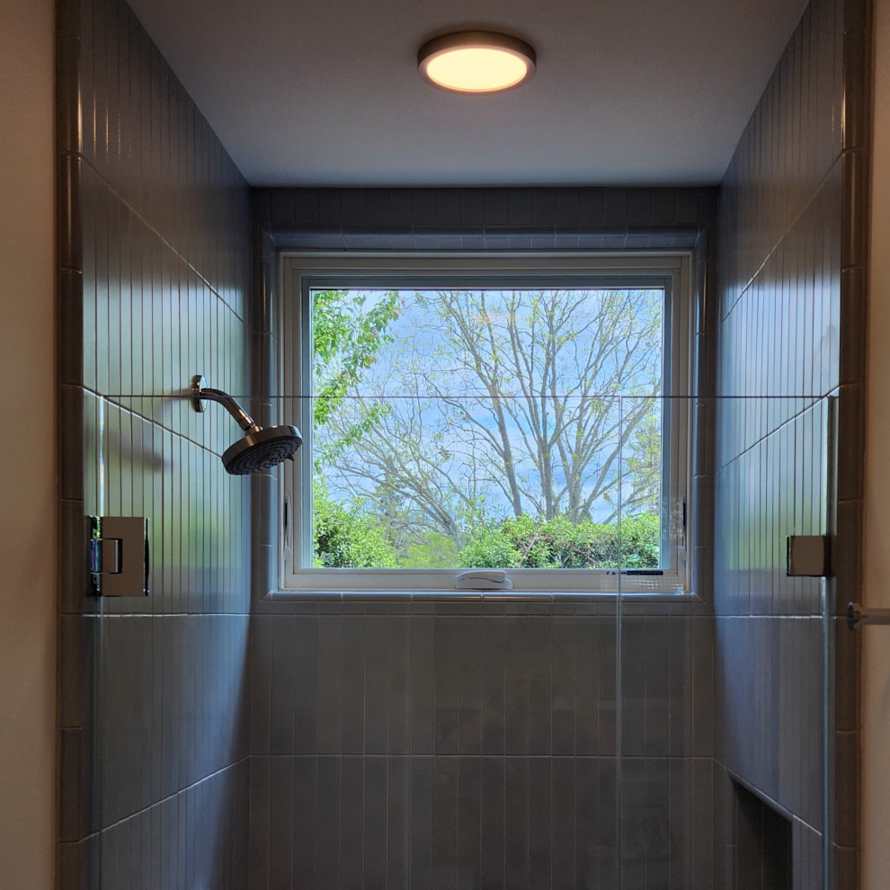 Photo of a large modern shower room bathroom in San Francisco with an alcove shower, stone tiles, grey walls, light hardwood flooring and a hinged door.