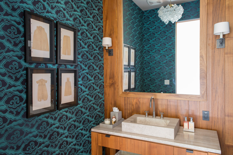 Beach style cloakroom in Los Angeles with flat-panel cabinets, medium wood cabinets, multi-coloured walls, a vessel sink, marble worktops, beige worktops, a built in vanity unit and wallpapered walls.