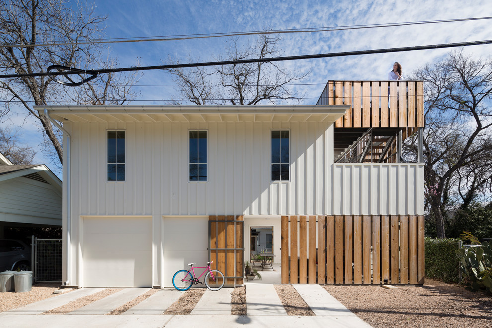 Transitional two-storey white apartment exterior in Austin with wood siding and a flat roof.