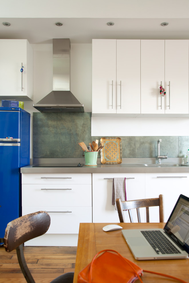 Photo of a mid-sized contemporary single-wall eat-in kitchen in Paris with white cabinets and no island.