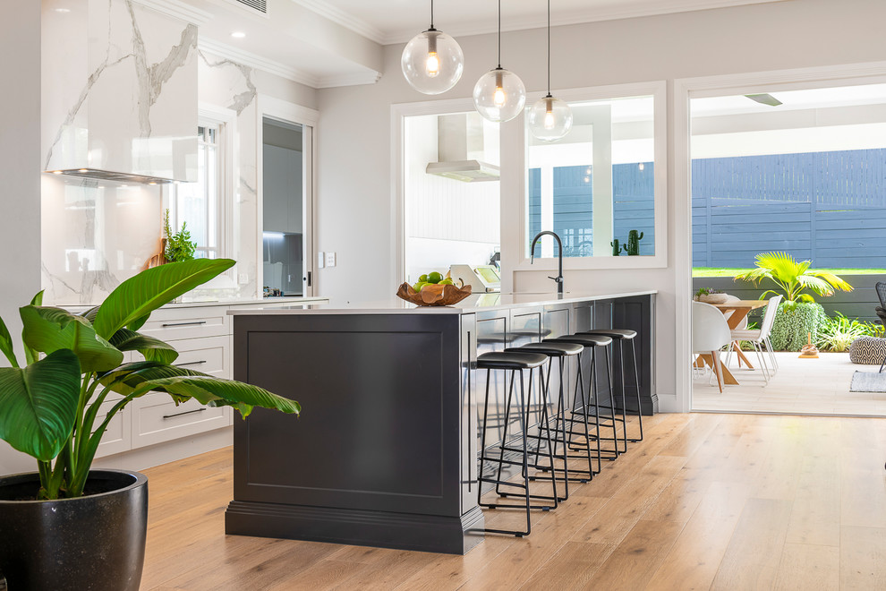 Design ideas for a large contemporary single-wall open plan kitchen in Brisbane with an undermount sink, shaker cabinets, grey cabinets, quartz benchtops, multi-coloured splashback, porcelain splashback, stainless steel appliances, light hardwood floors, with island and white benchtop.