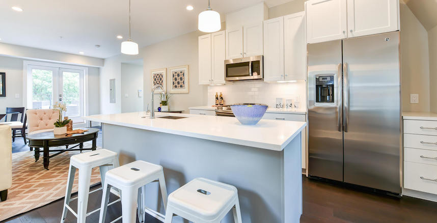 Example of a small transitional galley dark wood floor eat-in kitchen design in DC Metro with an undermount sink, shaker cabinets, white cabinets, quartz countertops, white backsplash, subway tile backsplash, stainless steel appliances and an island