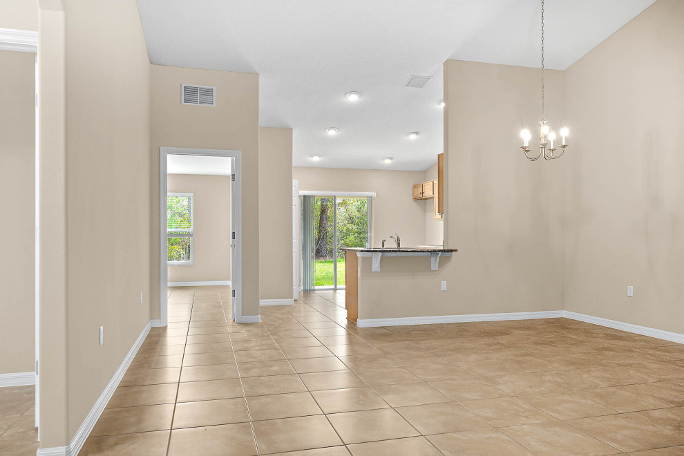 Inspiration for a mid-sized traditional open plan dining in Orlando with beige walls, ceramic floors and beige floor.