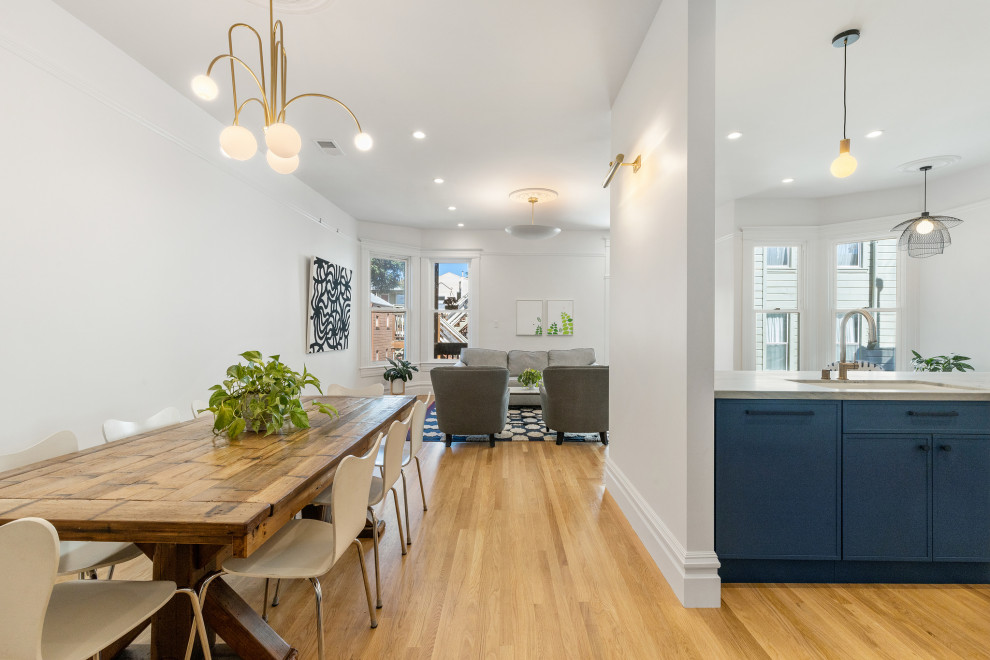 This is an example of a large traditional kitchen/dining combo in San Francisco with white walls, medium hardwood floors and brown floor.