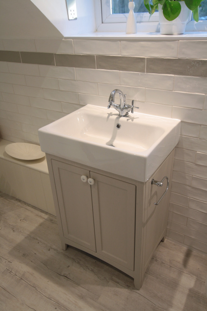 This is an example of a small traditional master bathroom in Oxfordshire with shaker cabinets, light wood cabinets, a corner shower, a two-piece toilet, white tile, ceramic tile, white walls, vinyl floors, a trough sink, white floor, a hinged shower door, a single vanity and a freestanding vanity.