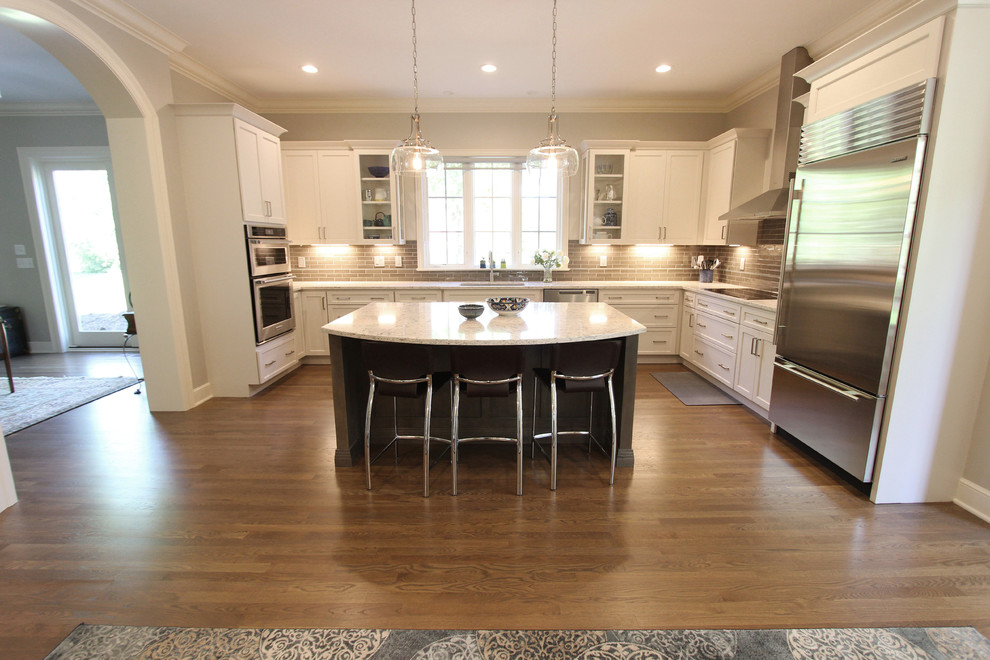 Design ideas for a large transitional eat-in kitchen in Columbus with an undermount sink, flat-panel cabinets, white cabinets, quartz benchtops, brown splashback, glass tile splashback, stainless steel appliances, light hardwood floors, with island and brown floor.