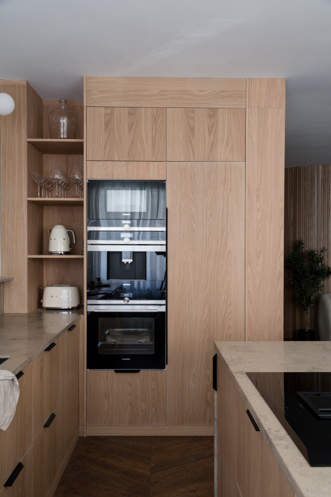 Inspiration for a mid-sized contemporary l-shaped open plan kitchen in Stockholm with a single-bowl sink, flat-panel cabinets, medium wood cabinets, limestone benchtops, beige splashback, limestone splashback, panelled appliances, medium hardwood floors, with island, brown floor and beige benchtop.