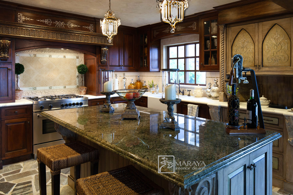 This is an example of a mid-sized u-shaped separate kitchen in Santa Barbara with a farmhouse sink, raised-panel cabinets, distressed cabinets, granite benchtops, beige splashback, marble splashback, panelled appliances, slate floors, with island, multi-coloured floor and green benchtop.