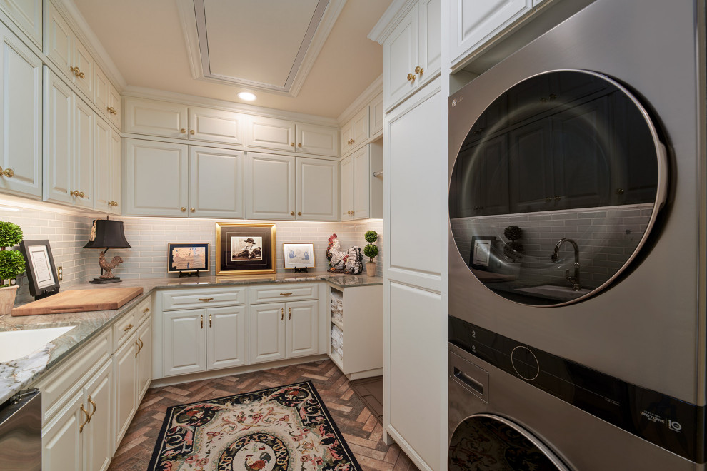 Photo of an expansive galley utility room in Other with an undermount sink, raised-panel cabinets, white cabinets, quartzite benchtops, green splashback, ceramic splashback, white walls, brick floors, a stacked washer and dryer, red floor and green benchtop.