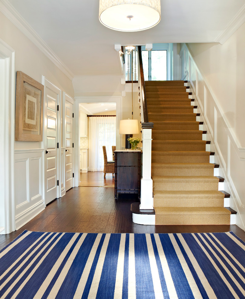 This is an example of a mid-sized transitional foyer in New York with beige walls, dark hardwood floors and a white front door.