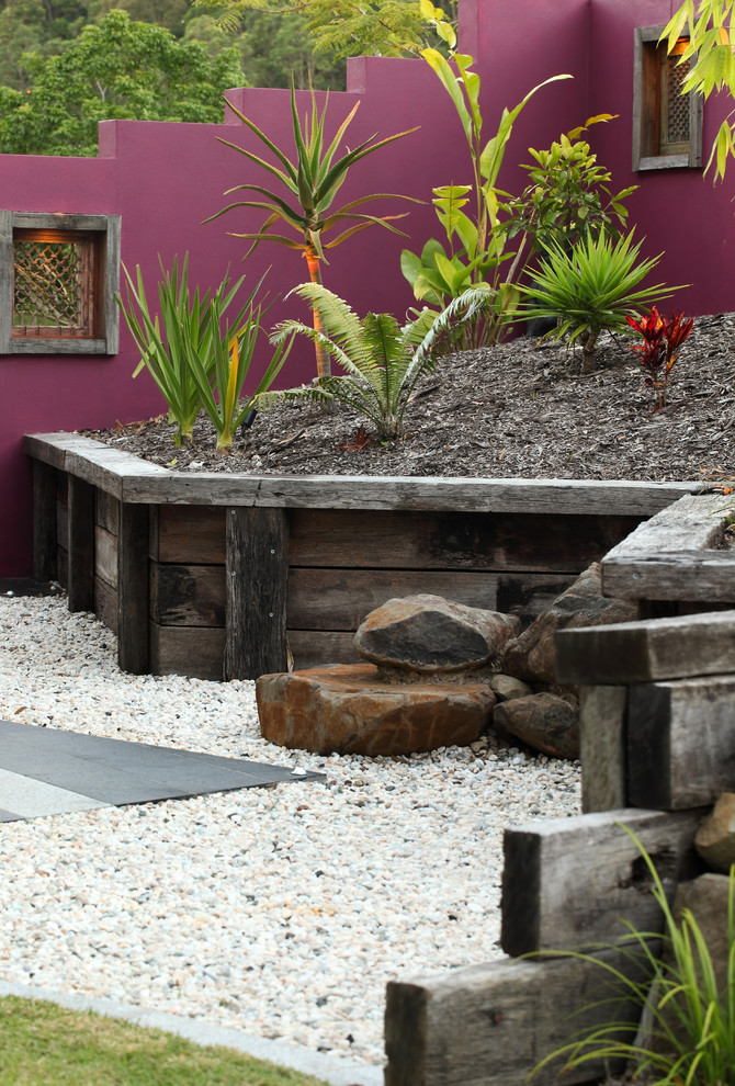 This is an example of a tropical garden in Sunshine Coast with gravel.