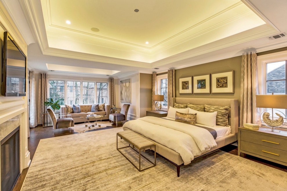 This is an example of a transitional master bedroom in New York with brown walls, medium hardwood floors, a standard fireplace, brown floor, recessed and panelled walls.