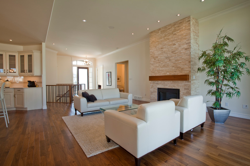 This is an example of a mid-sized transitional open concept living room in Edmonton with dark hardwood floors, a standard fireplace, a stone fireplace surround and no tv.
