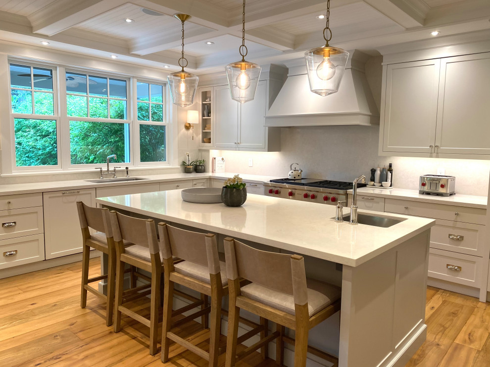 Mid-sized transitional u-shaped medium tone wood floor, brown floor and coffered ceiling open concept kitchen photo in Toronto with an undermount sink, shaker cabinets, quartz countertops, white backsplash, quartz backsplash, paneled appliances, an island and white countertops