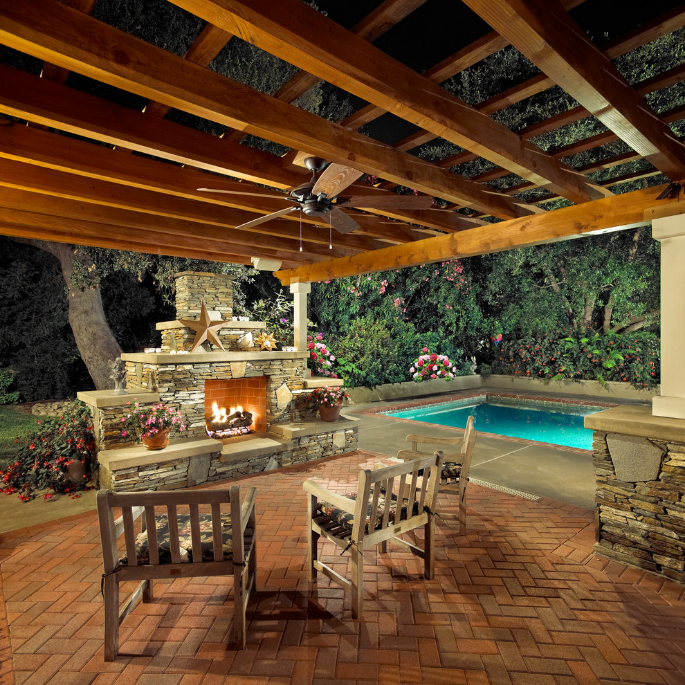 Mid-sized eclectic backyard patio in Los Angeles with a fire feature, brick pavers and a pergola.