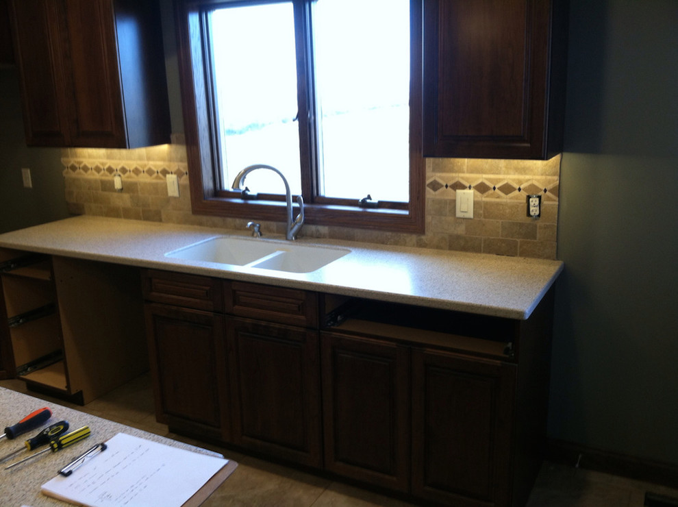 Trendy kitchen photo with a double-bowl sink, beaded inset cabinets, dark wood cabinets and an island