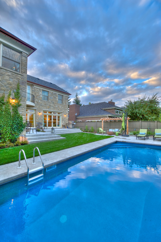 Design ideas for a mid-sized traditional backyard rectangular pool in Calgary.
