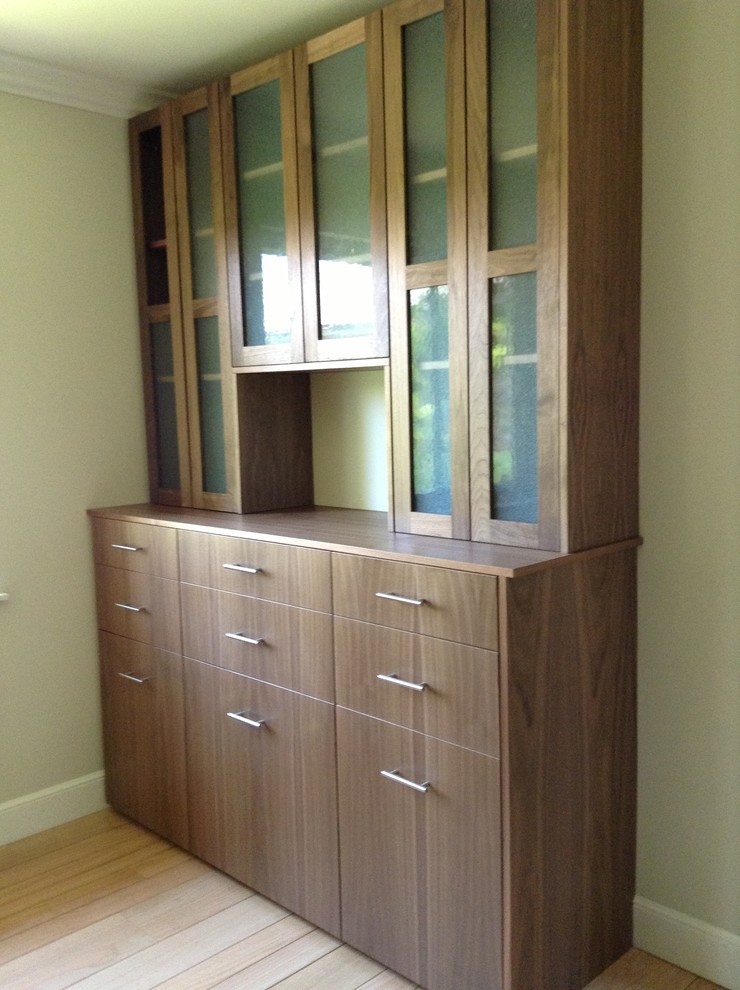 This is an example of a mid-sized contemporary gender-neutral walk-in wardrobe in San Francisco with flat-panel cabinets, medium wood cabinets and light hardwood floors.