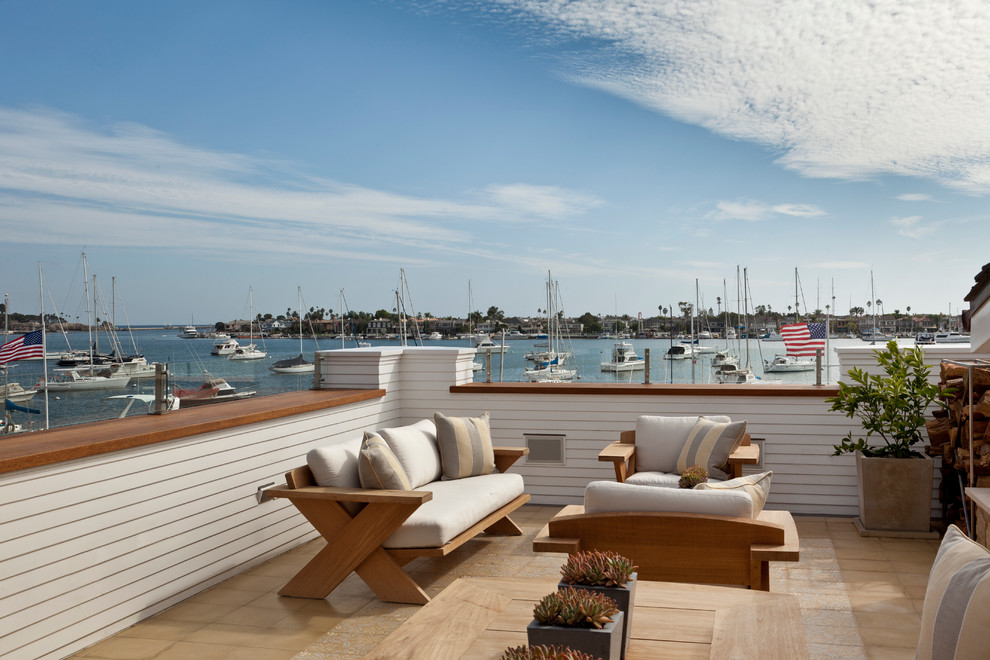 Inspiration for a large beach style rooftop deck in Orange County with no cover and with fireplace.