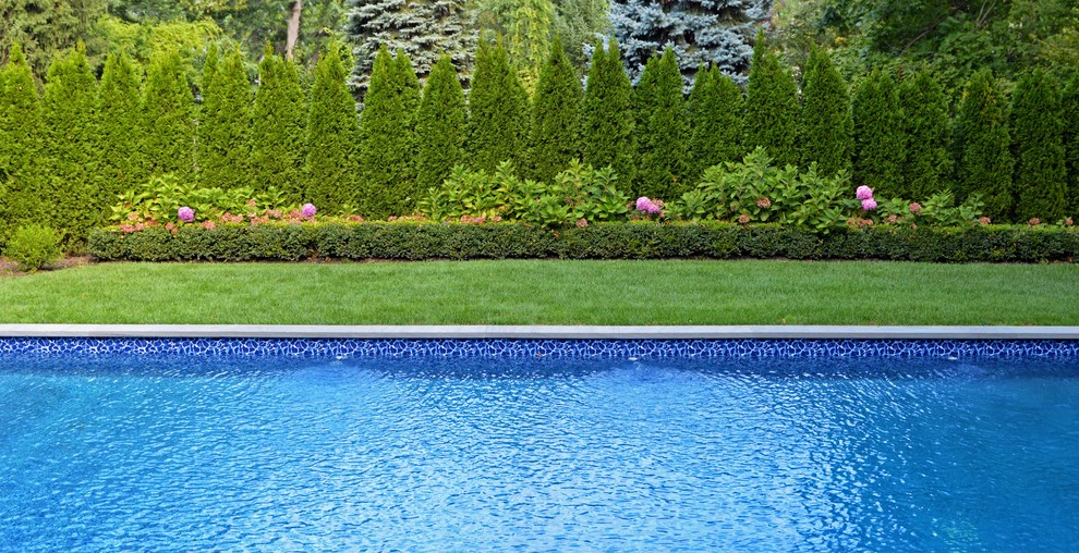 Inspiration for a mid-sized modern backyard rectangular pool in New York with a water feature and natural stone pavers.