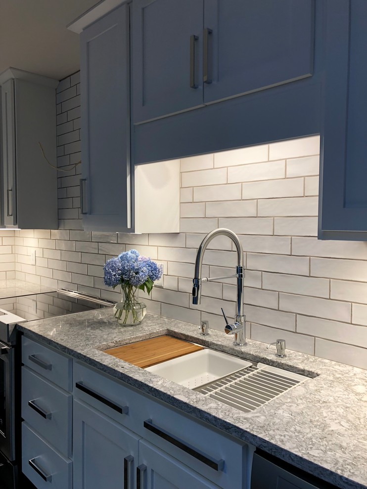 Example of a small transitional l-shaped porcelain tile and multicolored floor eat-in kitchen design with an undermount sink, shaker cabinets, white cabinets, quartz countertops, white backsplash, subway tile backsplash, stainless steel appliances, no island and white countertops