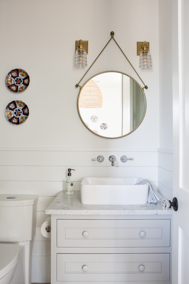 This is an example of a small country kids bathroom in Charleston with shaker cabinets, grey cabinets, an alcove tub, a shower/bathtub combo, a two-piece toilet, blue tile, glass tile, white walls, porcelain floors, a vessel sink, marble benchtops, grey floor, a shower curtain and grey benchtops.