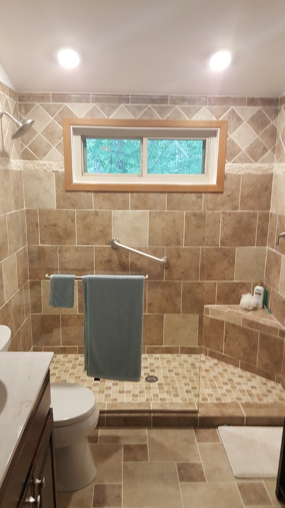 Photo of a mid-sized traditional 3/4 bathroom in DC Metro with raised-panel cabinets, medium wood cabinets, an alcove shower, a two-piece toilet, beige tile, limestone, white walls, limestone floors, an integrated sink, engineered quartz benchtops, beige floor and a sliding shower screen.