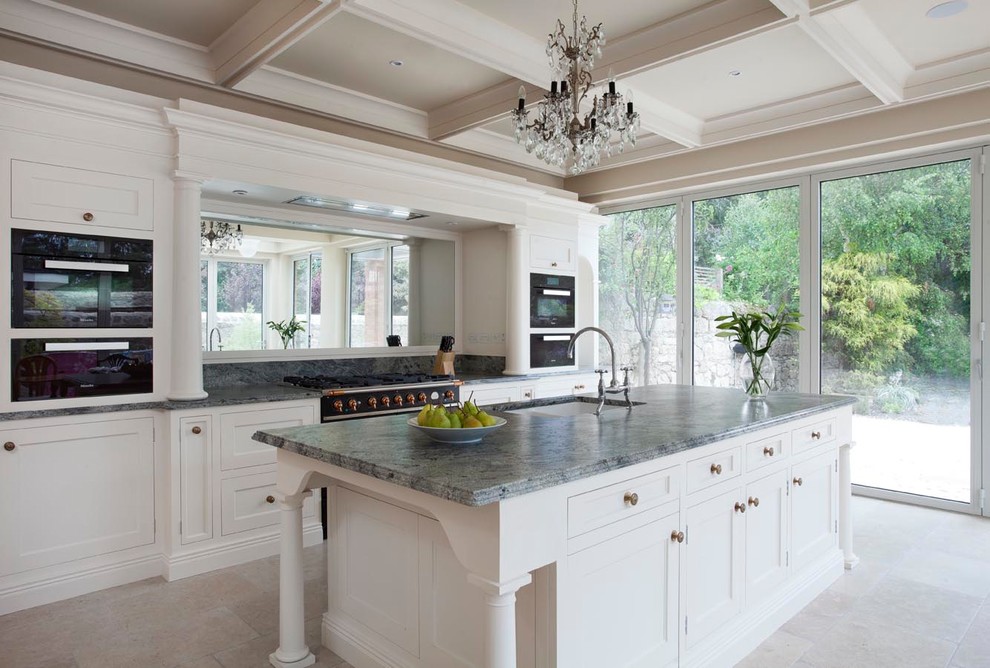 This is an example of a large traditional single-wall eat-in kitchen in Dublin with a drop-in sink, shaker cabinets, white cabinets, quartzite benchtops, mirror splashback, black appliances, ceramic floors, with island, grey floor and green benchtop.