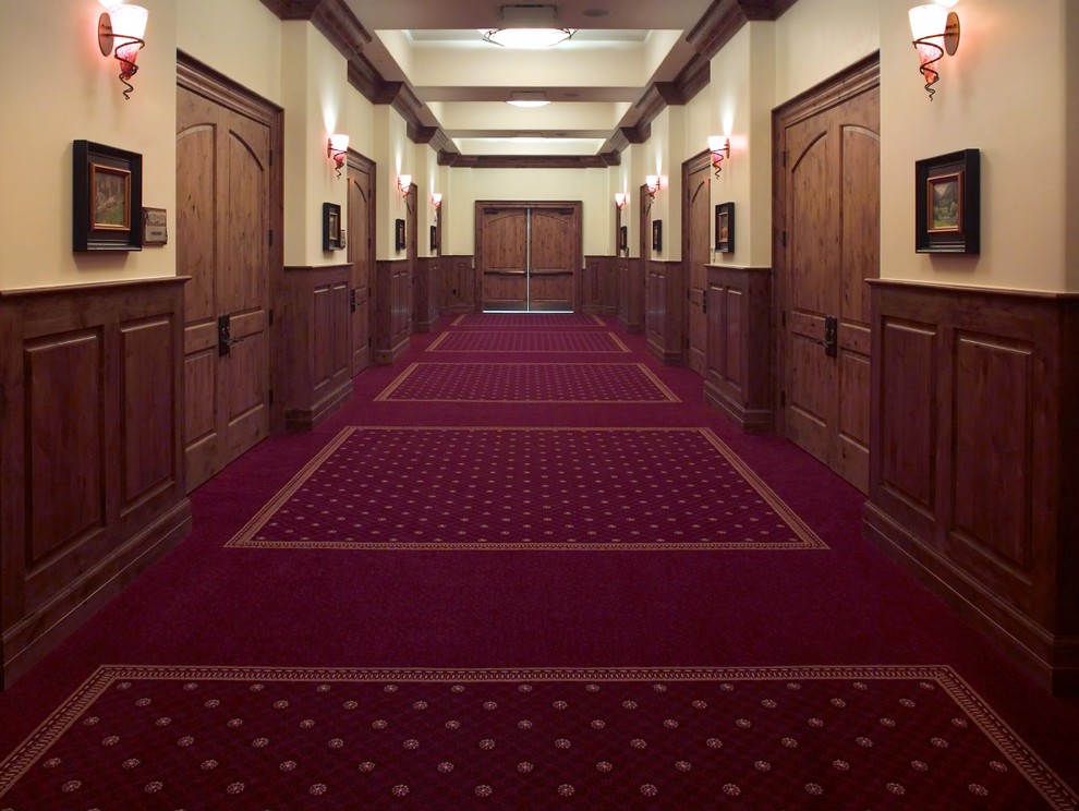 Inspiration for an expansive traditional hallway in Denver with beige walls, carpet and red floor.