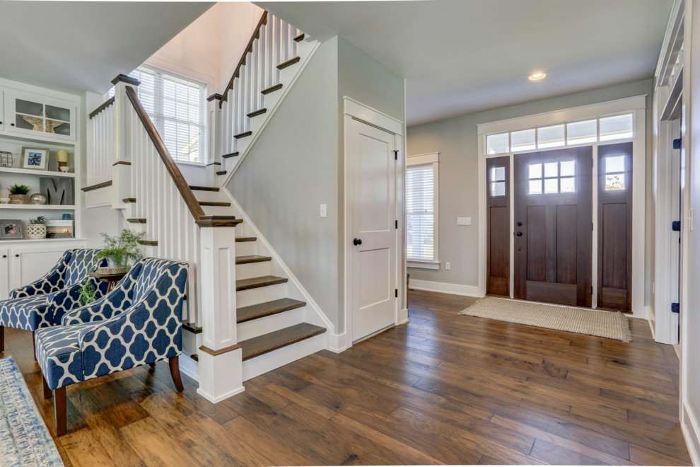 This is an example of a large country front door with grey walls, medium hardwood floors and brown floor.