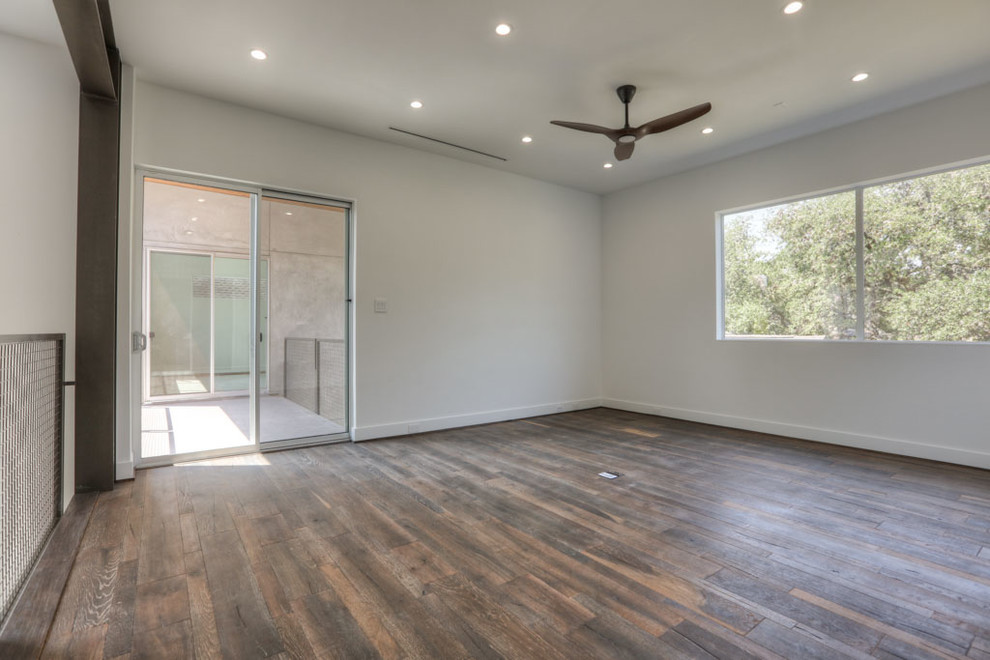 Photo of a mid-sized modern hallway in Houston with white walls, dark hardwood floors and brown floor.