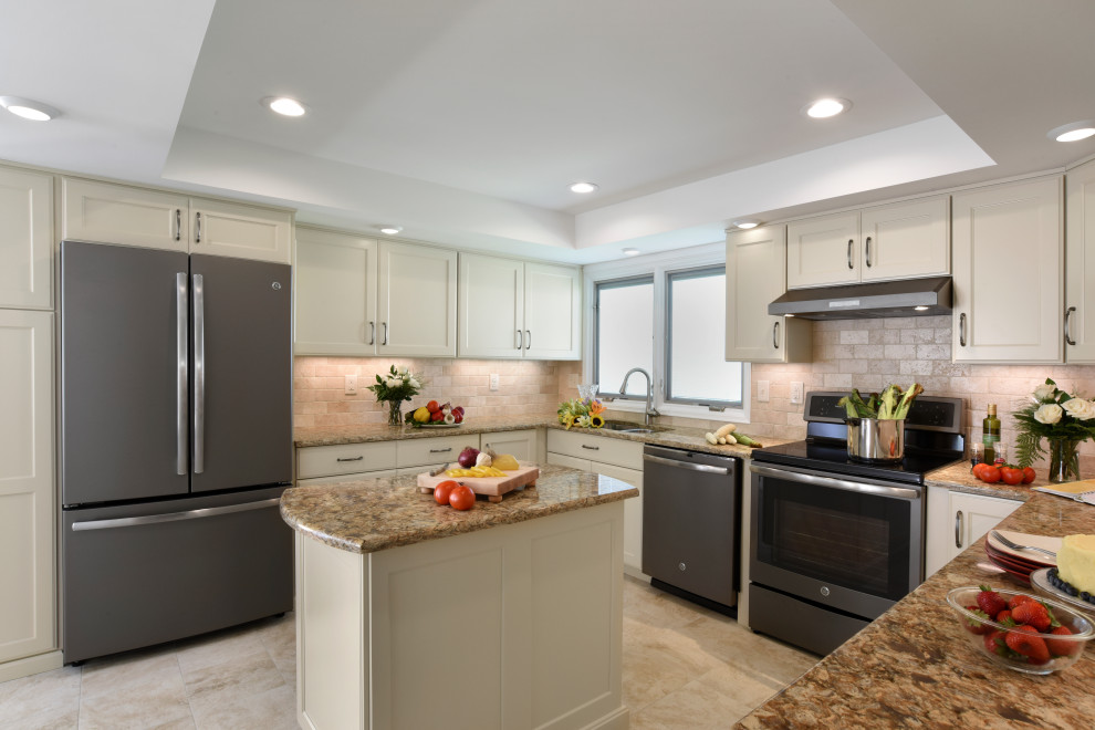Inspiration for a mid-sized transitional u-shaped porcelain tile, beige floor and tray ceiling enclosed kitchen remodel with an undermount sink, flat-panel cabinets, beige cabinets, quartz countertops, beige backsplash, travertine backsplash, black appliances, an island and beige countertops