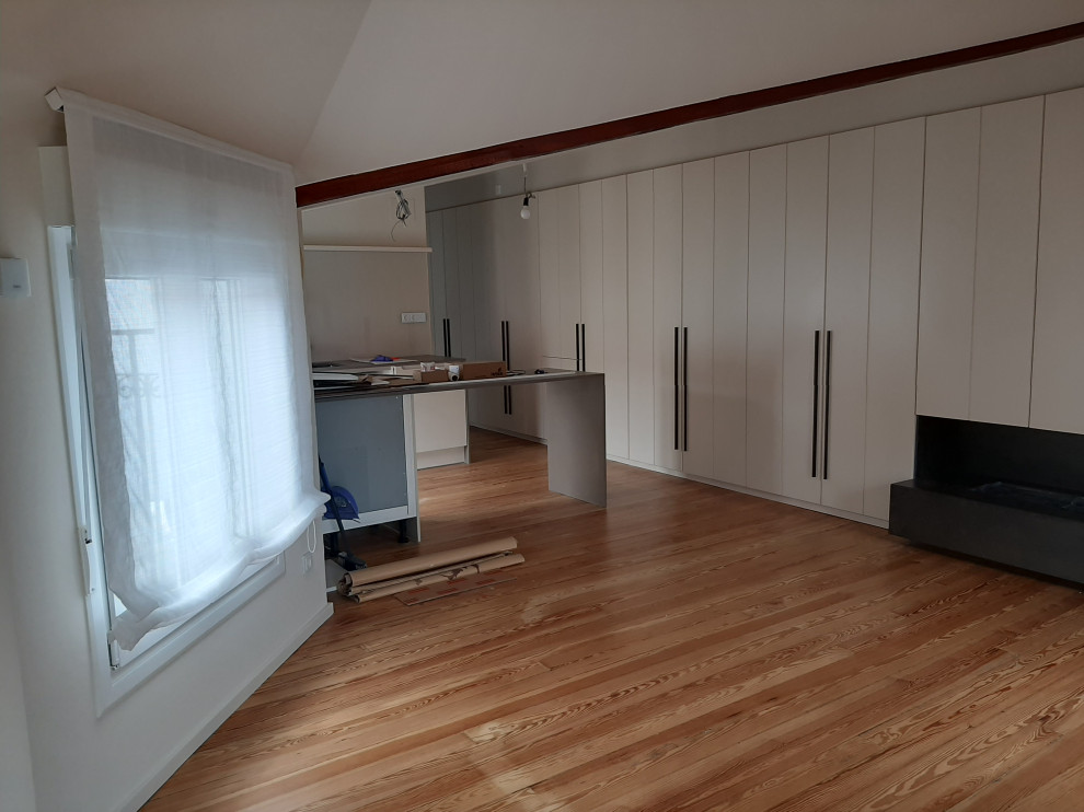 Modelo de armario de mujer contemporáneo pequeño con armarios con paneles empotrados, puertas de armario beige, suelo de madera clara, suelo beige y vigas vistas