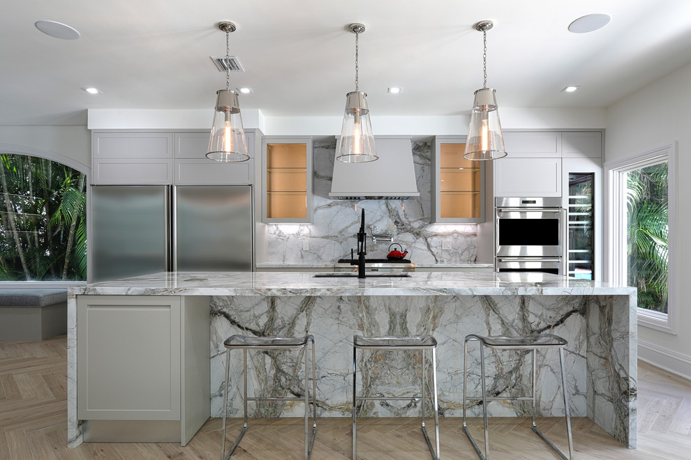 This is an example of a large beach style galley kitchen in Miami with an undermount sink, grey cabinets, marble benchtops, multi-coloured splashback, stainless steel appliances, light hardwood floors, with island, beige floor, multi-coloured benchtop, shaker cabinets and stone slab splashback.