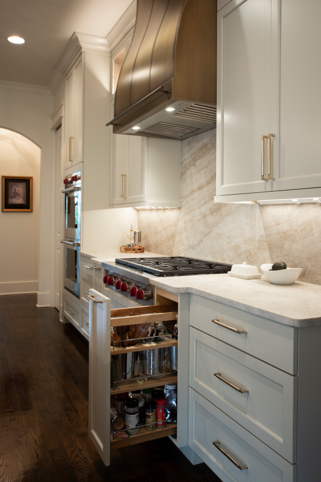 Large transitional l-shaped dark wood floor and brown floor open concept kitchen photo in Nashville with an undermount sink, beaded inset cabinets, white cabinets, quartzite countertops, beige backsplash, stone slab backsplash, stainless steel appliances, an island and beige countertops