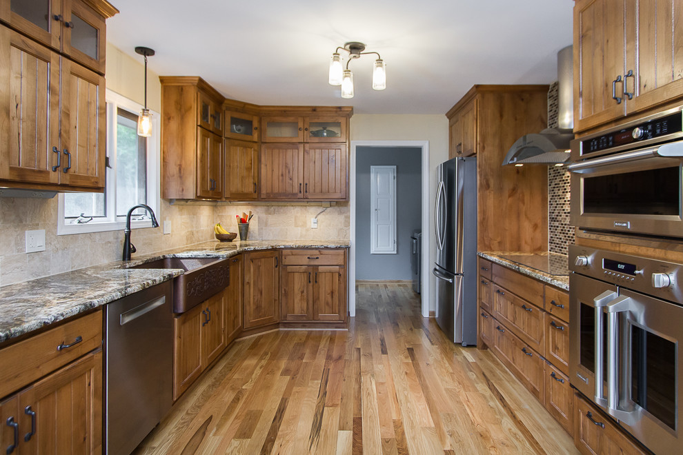 Eat-in kitchen - large rustic light wood floor eat-in kitchen idea with a farmhouse sink, light wood cabinets, granite countertops, beige backsplash, glass tile backsplash, stainless steel appliances and beige countertops